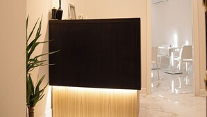 A modern reception area with a dark reception desk, a potted plant, and a marble floor. - Roxy luxury house Rome (Rome)