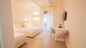 A hotel room with a bed, a desk with a chair, a TV mounted on the wall, and a window with curtains. - Roxy luxury house Rome (Rome)