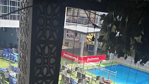 A poolside area with chairs and tables, a pool, and a stage with a banner. - De Glen Hotel And Suites (Owerri)