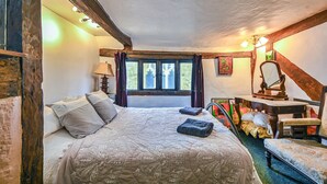 Un dormitorio acogedor con una cama, un escritorio y una ventana.