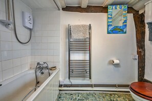 A bathroom with a bathtub, a towel rack, a toilet, and a showerhead. - Old Town Cottage, Hastings (Hastings)
