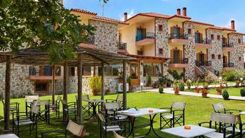 A courtyard with outdoor seating and a stone building with multiple balconies.