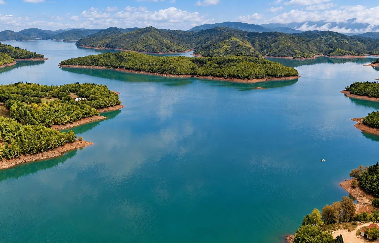Un extenso cuerpo de agua con varias islas, rodeado de colinas.