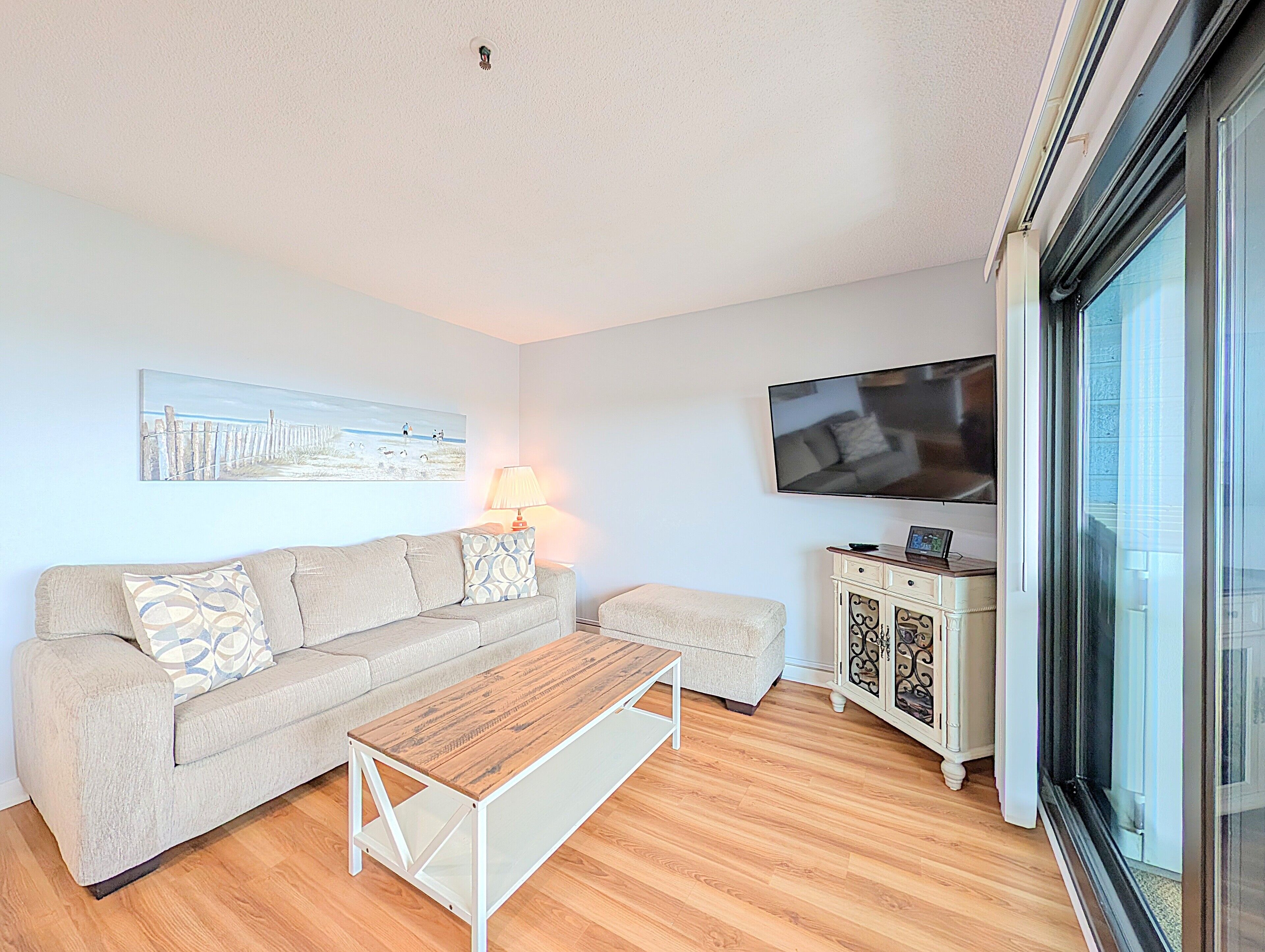 A living room with a sofa, a coffee table, a TV, and a cabinet.