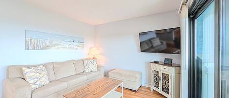 A living room with a sofa, a coffee table, a TV, and a cabinet.