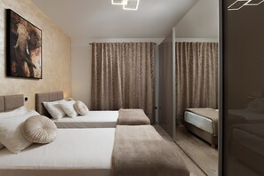 Ein modernes Hotelzimmer mit zwei Betten, einem großen Spiegel und einem Elefantenbild.