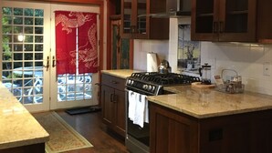 Una cocina con armarios de madera, una estufa a gas y un horno de acero inoxidable.