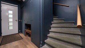 Eine Treppe mit Handlauf, eine Tür mit satinierten Glasscheiben und eine hölzerne Bank.