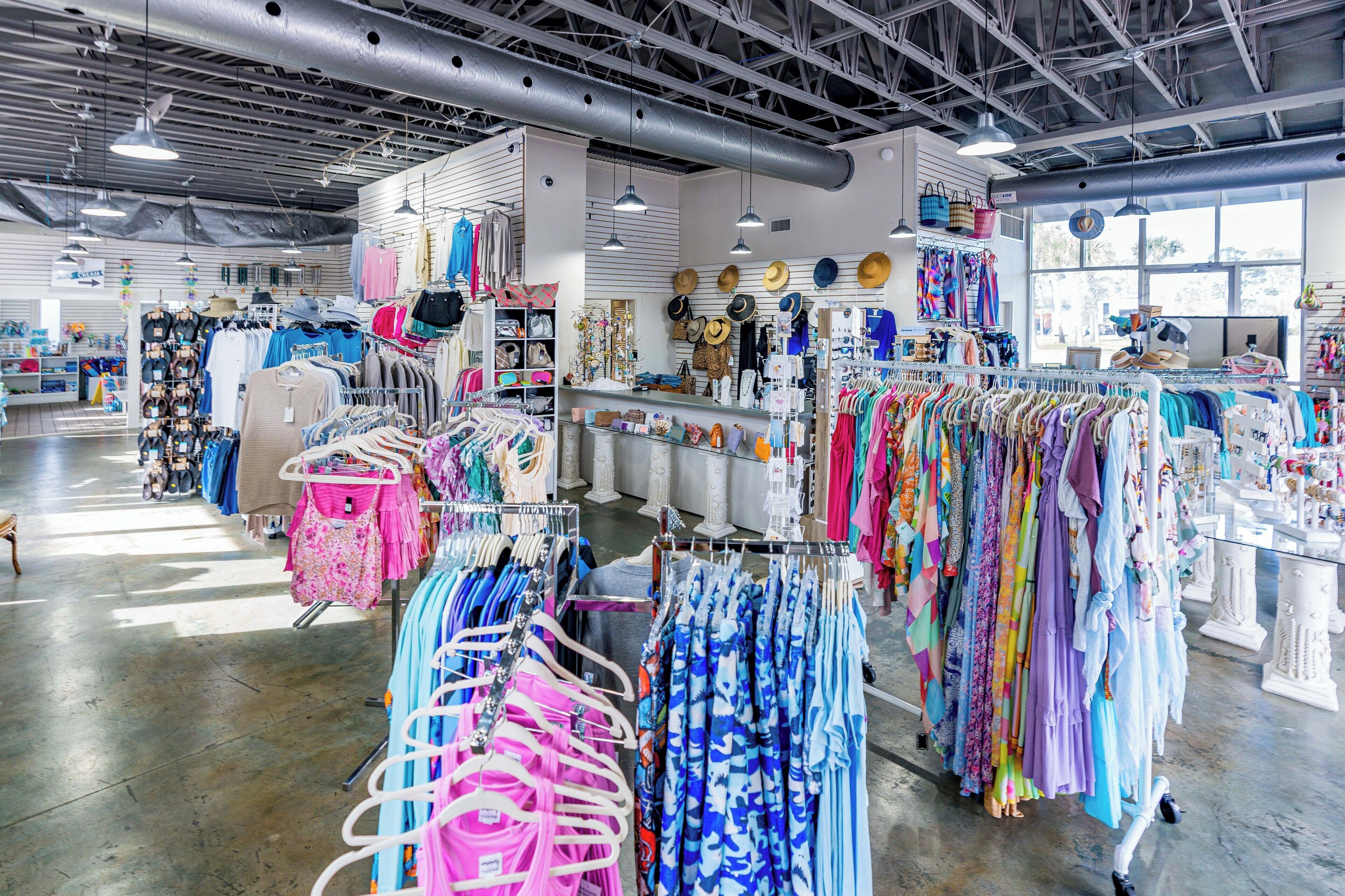 A clothing store with racks of colorful garments, a variety of hats, and accessories.