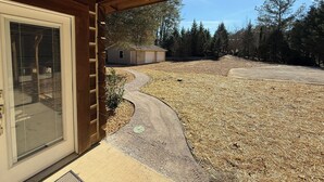 A covered porch with a view of a backyard, a garage, and a house. - The Last Bend Lodge, cozy and private home on the Coosa River! (Gadsden)