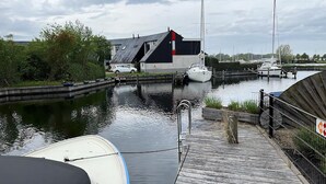 Ein Yachthafen mit vertäuten Booten, eine Holzsteg und ein Gebäude mit geneigtem Dach.
