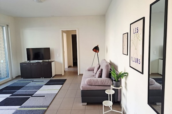 A modern living room with a sofa, TV, and artwork on the wall. - Close to the Heart of Lugano (Mola Glicine) (Lugano)