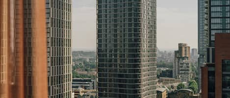 Ein Hochhaus mit geschwungener Fassade, umgeben von weiteren modernen Gebäuden und einem Fluss.