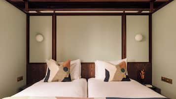 A double bed with a geometric-patterned bedspread, two pillows with a dog design, and a wooden headboard.