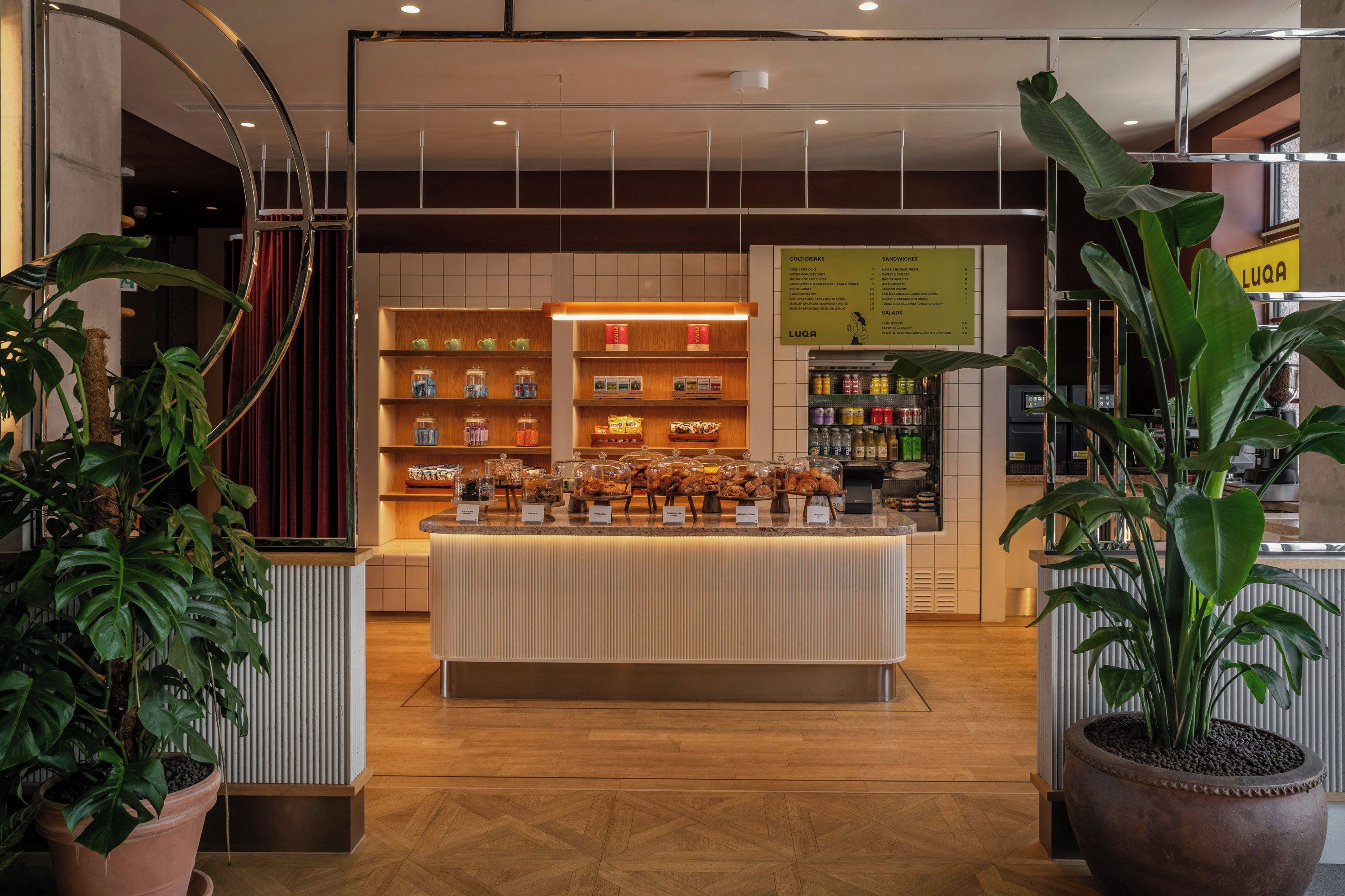 A bakery counter with various baked goods and a menu board in the background.