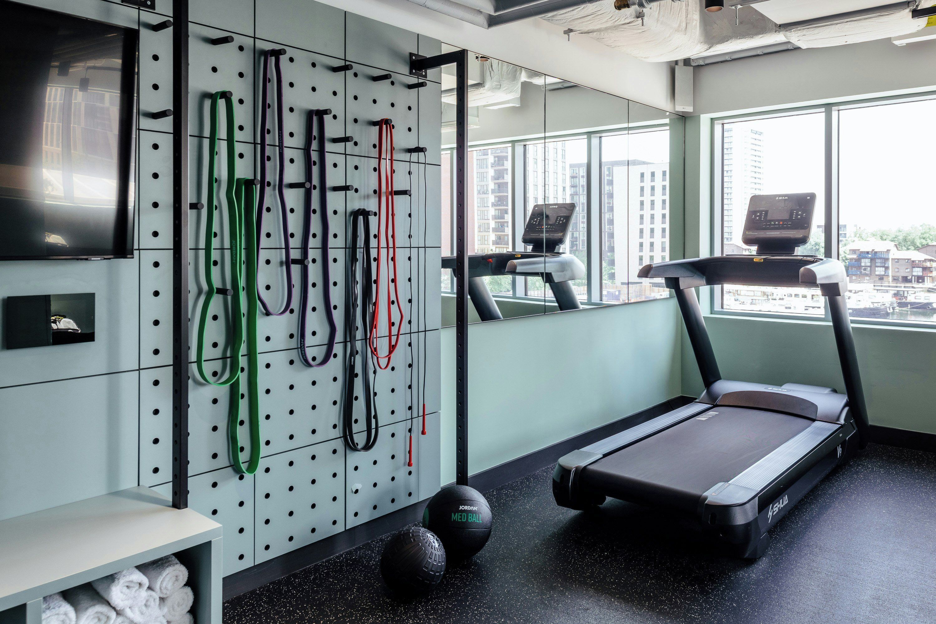 Una palestra con tapis roulant, palle da ginnastica e fasce elastiche.