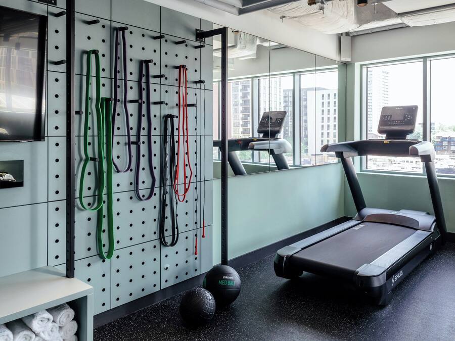 A gym with a treadmill, exercise balls, and resistance bands.