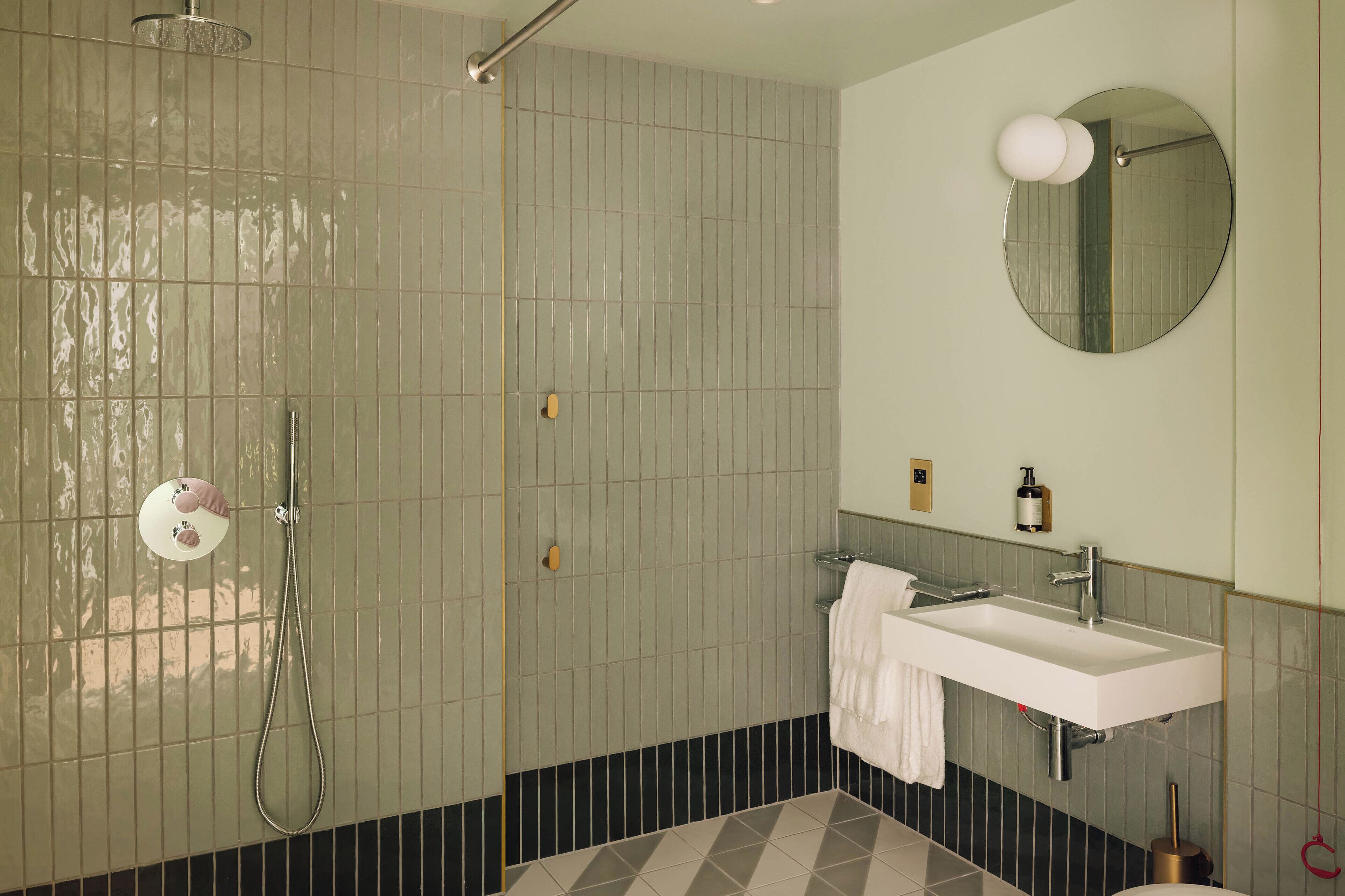 Un baño con ducha, lavabo y espejo.