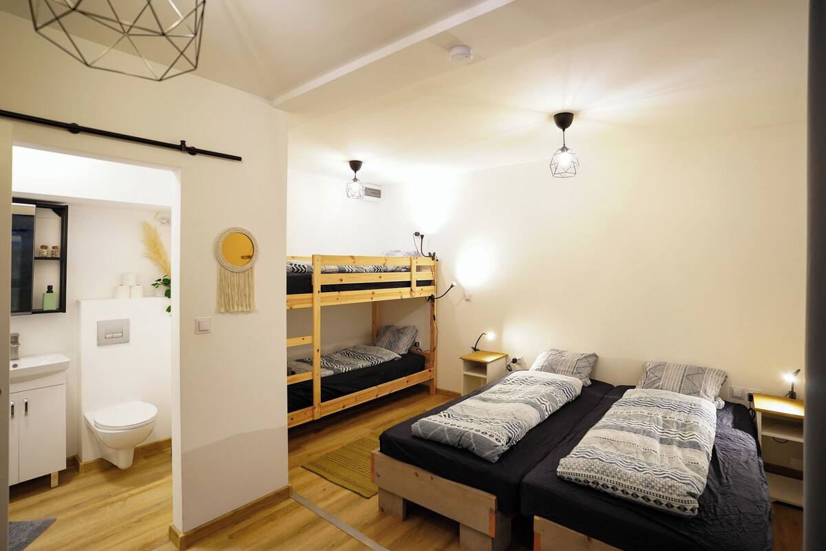 Ein gemütliches Schlafzimmer mit Etagenbetten, einem Nachttisch mit Lampe und einer kleinen Ablage.