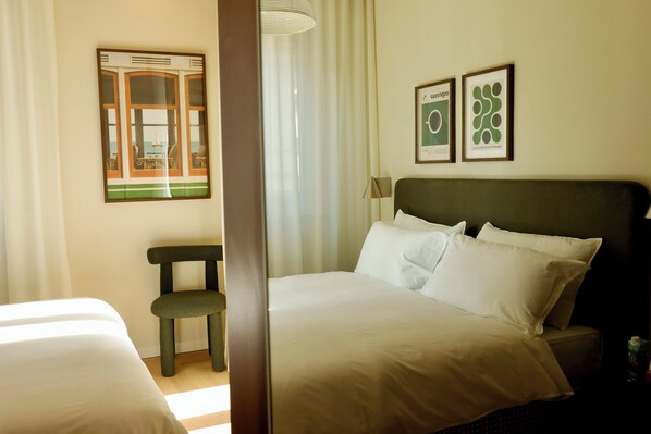 A hotel room with a bed, a chair, and two framed artworks on the wall. - Brand-New 2BR Apartment in the Heart of Como, Duomo View (Como)