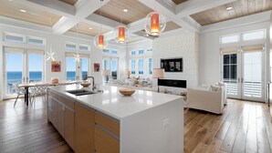 A spacious kitchen with a large island, wooden flooring, and pendant lighting. - Sealah Huge Beachfront Home + Private Pool & Bikes (Inlet Beach)