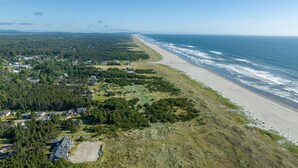 An aerial view of a coastal area with a beach, forested land, and residential buildings. - NEW! Ocean View, Hot Tub, Game Room (Nant@Beach) (Ocean Park)