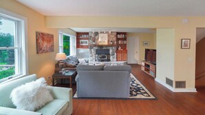 A living room with a fireplace, a sofa, a coffee table, and a TV.
