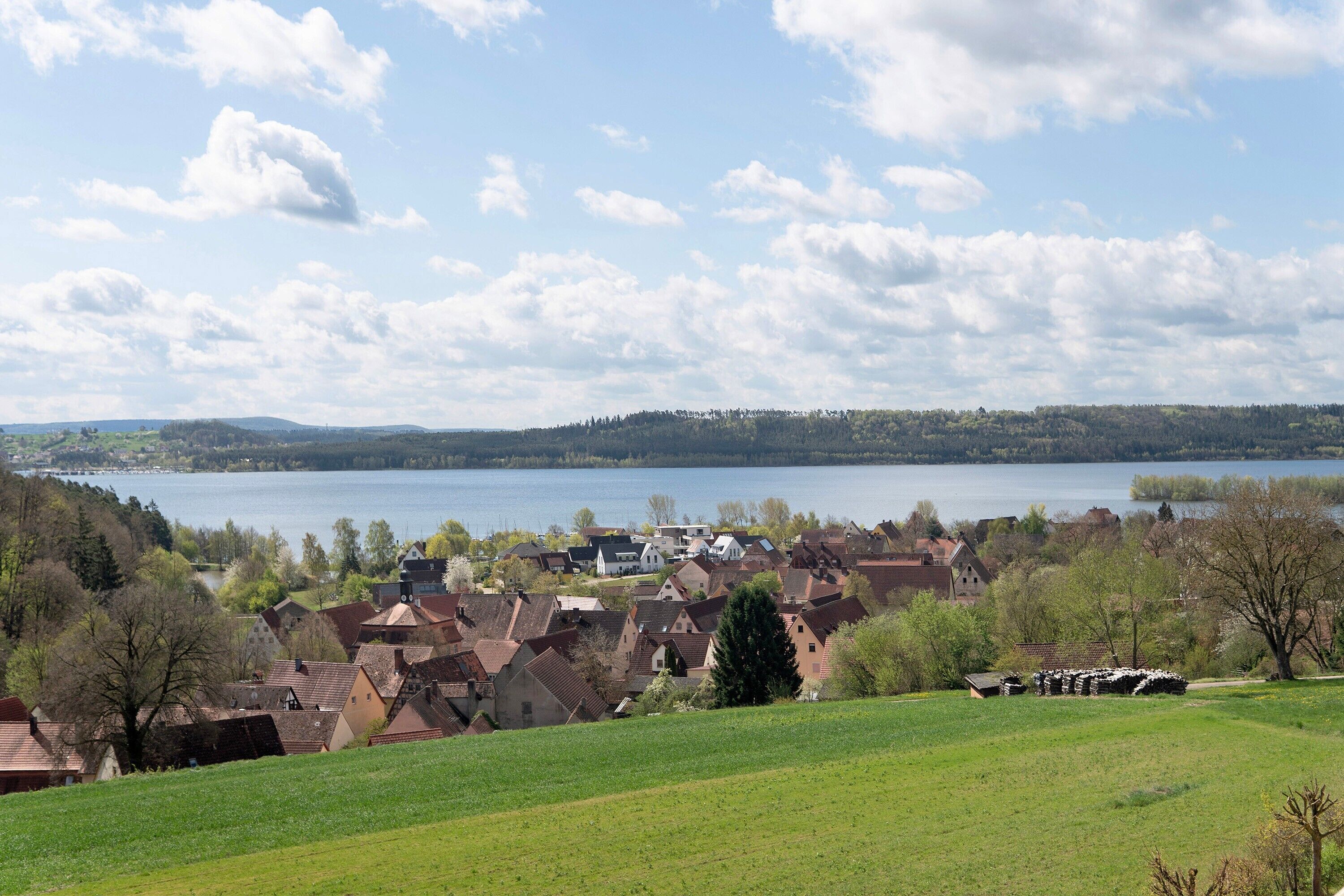 Un pueblo a orillas del lago con casas tradicionales, cielo despejado y vistas al lago.