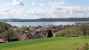 A lakeside village with traditional houses, a clear sky, and a view of the lake. - Family Apartment with Lake View (Spalt)