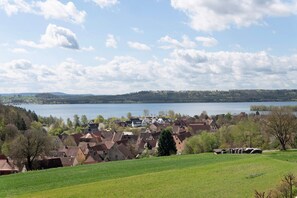 A lakeside village with traditional houses, a clear sky, and a view of the lake. - Family Apartment with Lake View (Spalt)