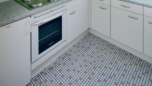 Eine Küche mit eingebautem Backofen, einer Mikrowelle und einem Spülbecken.