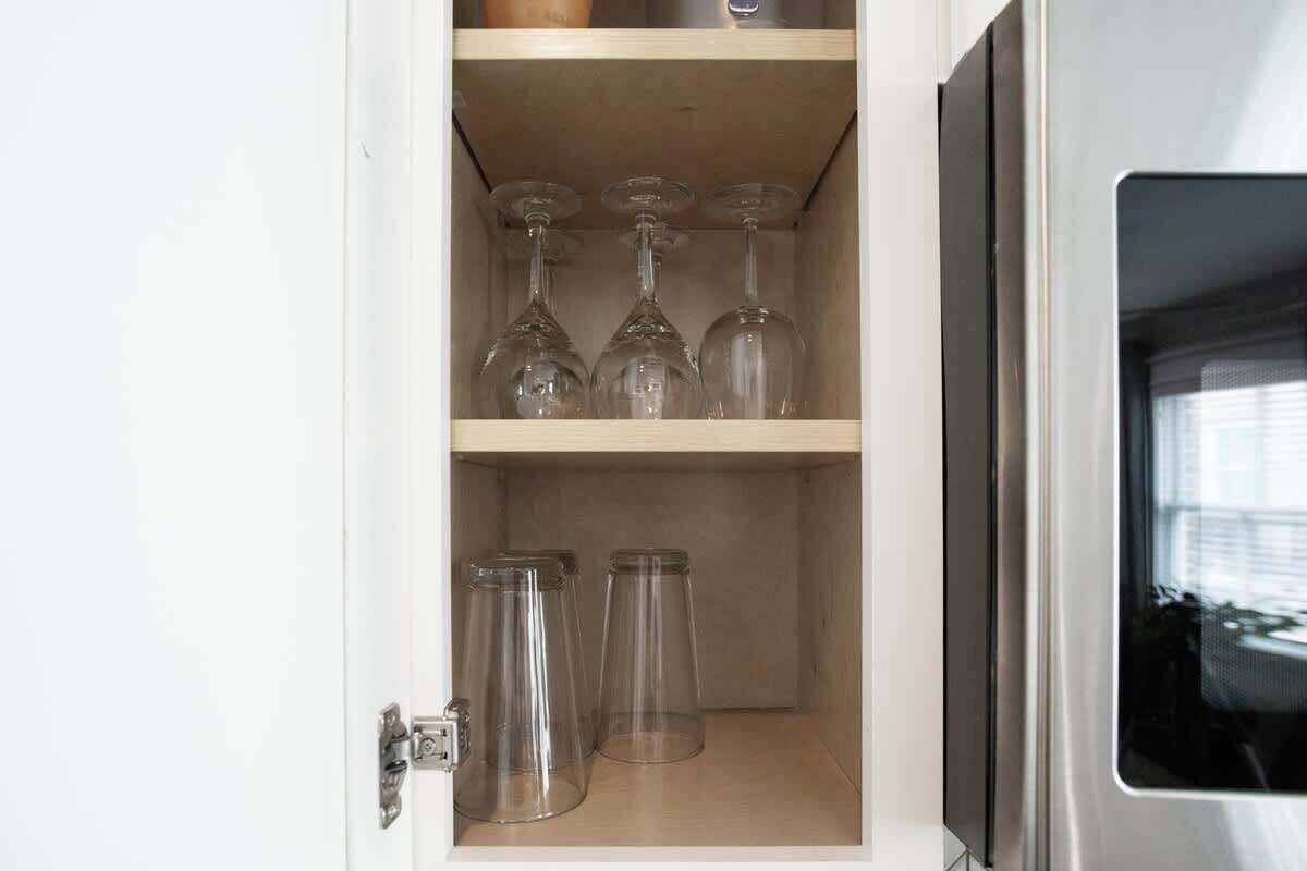 Un mueble con copas de vino y frascos de vidrio.