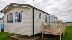 A mobile home with a small deck and a single window. - MP416 Parkdean Resorts Camber Sands (Camber)
