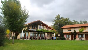 A two-story building with a patio area, outdoor seating, and a well-maintained lawn. - Country House 'Villabamba 4' with Mountain View, Shared Terrace and Wi-Fi (Valdeavellano de Tera)