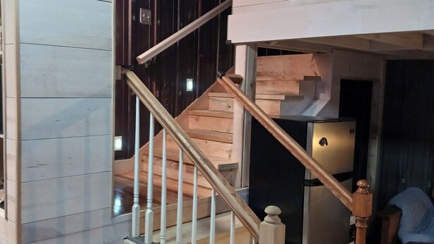 A staircase with wooden steps and white balusters, leading to a landing with a light fixture. - Loft suite with cozy Queen minutes from Makers Mark , Log Still , Gethsamane (Loretto)