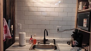 A kitchen with a stainless steel sink, white cabinets, and a tiled backsplash. - Loft suite with cozy Queen minutes from Makers Mark , Log Still , Gethsamane (Loretto)