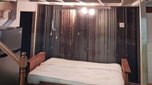 A bunk bed with a wooden headboard and a mattress. - Loft suite with cozy Queen minutes from Makers Mark , Log Still , Gethsamane (Loretto)