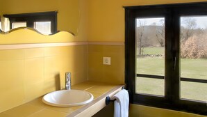 Une salle de bain avec un lavabo, un miroir et une fenêtre.