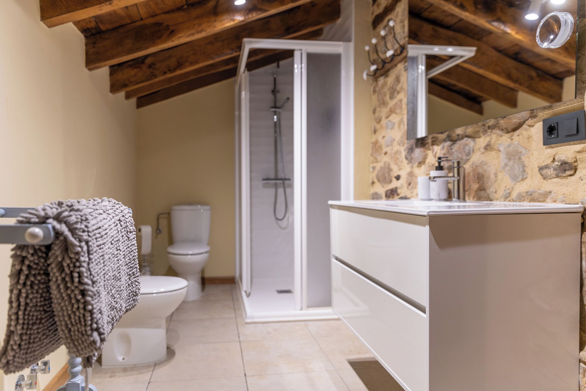 A modern bathroom with a shower, toilet, and a vanity with a sink.