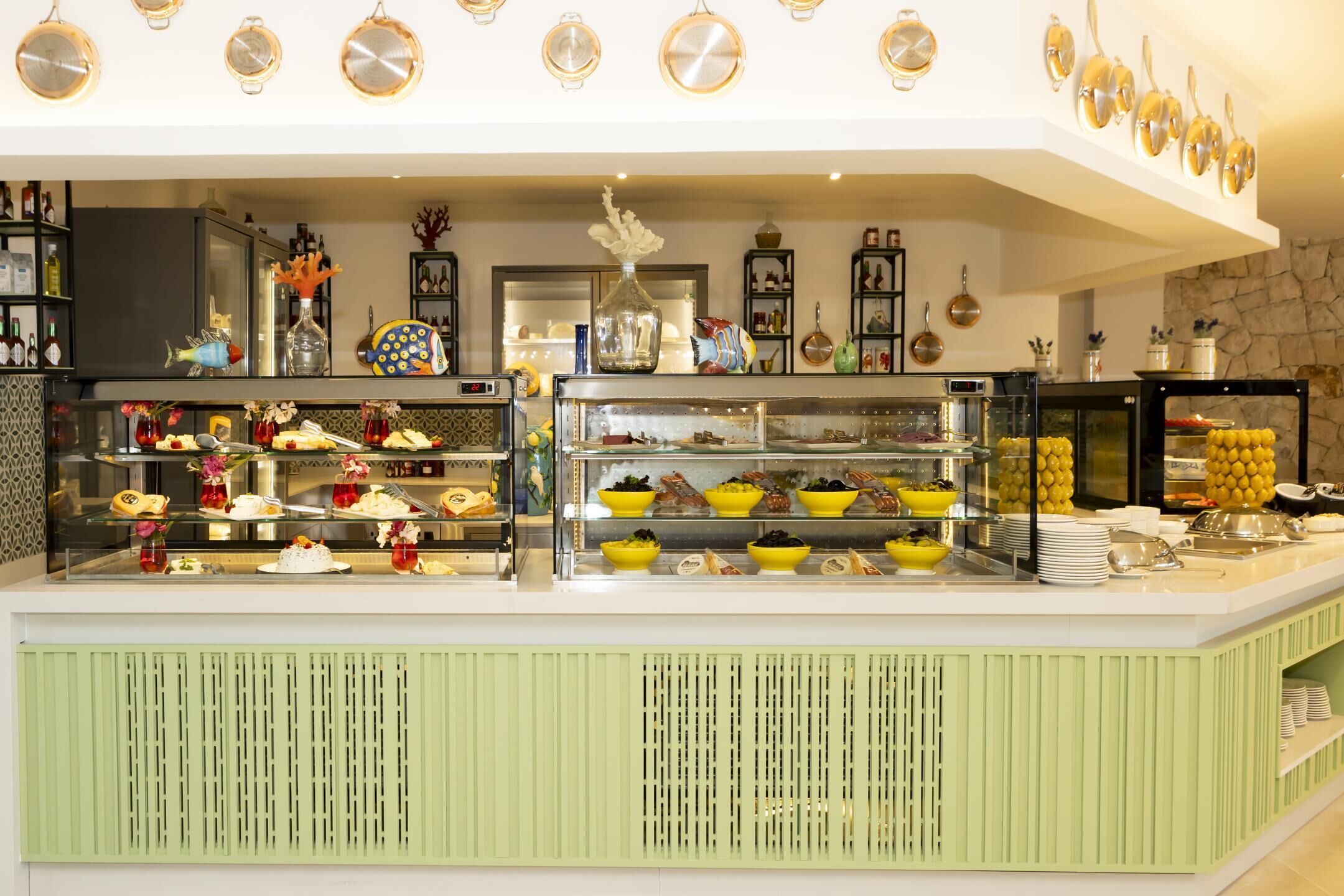 A buffet with various food items, a glass display case, and decorative items on shelves.