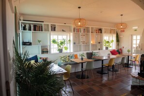 A modern interior with a seating area, bookshelves, and potted plants.