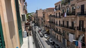 Eine schmale Straße, gesäumt von mehrstöckigen Gebäuden, von denen einige Balkone und Klimaanlagen haben.