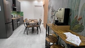 Eine moderne Küche mit Esstisch, Stühlen und einer Kaffeemaschine.