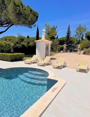 A swimming pool with lounge chairs, a small white building, and a gate. - Casa Vilamoura Luxe | Luxury 9BR retreat | Walk to Marina | Vilamoura (Quarteira)