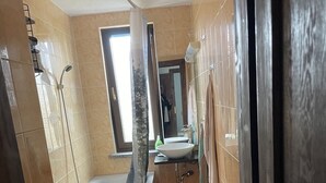 Et badeværelse med badekar, toilet og håndvask.