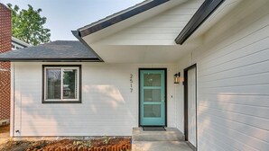 A single-story house with a white exterior, a green door, and a small porch area. - Charming Sunset Park Stay Near Parks & Greenbelt (Boise)