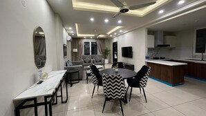 A modern living room with a dining area, a ceiling fan, recessed lighting, a flat-screen TV, and a kitchen area with a sink and countertop. - Said's Suites Elysium tower opposite to centaurus mall Islamabad (Islamabad)