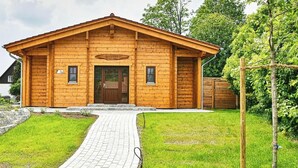 Una baita di legno con un vialetto in mattoni che conduce all'ingresso.