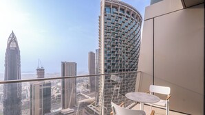 A balcony with a glass railing overlooking a cityscape with modern buildings. - Luxurious 2BD in Address Residences Opera Walk to Dubai Mall & Burj Khalifa (Dubai)