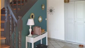 A staircase with dark balusters, a white console table with a lamp, a mirror, and a hanging light fixture. - Summer rental Villa & pool Lons le Saunier (Courlans)